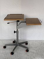 Side view showing two wooden platforms mounted on metal adjustable frame with caster wheels.