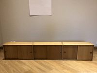 Three oak wall cabinets lined up side by side, front view