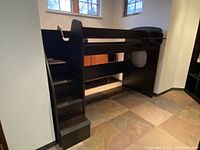 Full view of the dark melamine stair loft bed frame placed in corner of room with twin mattress space on top and attached side shelf.