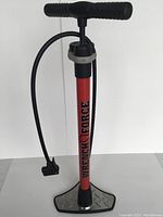 Full front view of the red Wrench Force Air Daddy bicycle floor pump showing the T-shaped handle, hose, and large base.