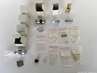 Overview of all items including boxed door viewers, loose door viewers, and plastic bags containing optical lenses and parts, arranged on a white surface