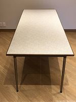 Top view showing white Formica surface and teak wood edge trim, with metal legs visible.