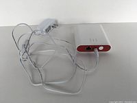 Front side view of the red and white Honeywell RedLINK Internet Gateway showing power adapter and ethernet port