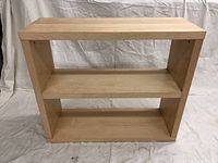 Front view showing the three open compartments and overall maple finish of the bookcase.