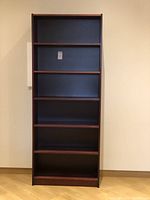 Front view of the maroon IKEA Billy bookcase showing full height and shelves.