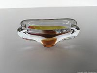 Side view showing clear thick glass walls and amber interior base