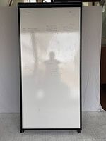 Front view of the whiteboard side of the mobile easel showing some writing and reflection, with minor surface scratches visible on the lower left corner.
