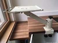 Platform arm mounted on table edge showing the platform with cutouts and keyboard rack.