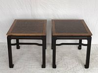 Front view of both tables showing rectangular tops with burled wood veneer and light wood borders, dark bases with square legs and stretchers