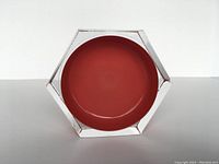 Front view of vintage hexagonal orange glass bowl showing orange inner and clear outer hexagonal shape.