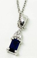 Close-up of pendant front showing blue sapphire and three diamonds