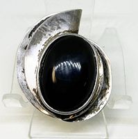 Front view of the sterling silver brooch highlighting the black onyx stone and oxidized patina on the silver frame.