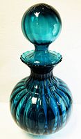 Full height side view of teal blue glass decanter with spherical stopper