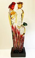 Full front view of the multicolored glass sculpture on black base
