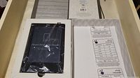 Kobo Touch Edition e-reader in original box with screen protector on and charging cable visible inside the box.