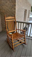 Front view showing slatted seat, spindle arms, curved rockers
