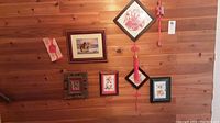 Wide view of all eight Asian decor art pieces mounted on wooden wall, showing size and arrangement.