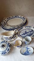 Overview of all items showing platters, soup bowl with lid, gravy boat, small jug, cup, and plates with blue and white designs