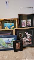 Overview of 6 framed pieces including fabric elephants and dancer, watercolor paintings, and relief sculpture