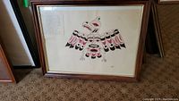 Full view of framed Kwakiutl Thunderbird drawing in wooden frame with glass and beige matte, showing full artwork and frame condition.