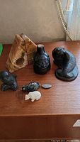 Wide shot of the entire set of stone figurines and marble bookends on wooden surface