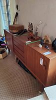 Full view of teak buffet cabinet with decorative items on top