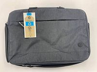 Front view of new grey HP laptop bag with tags attached visible.