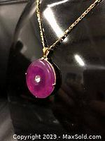 Close-up of purple jade circular pendant disc showing smooth surface and central hole