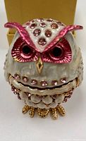 Front view of the owl egg box showing white enamel with pink metallic accents and rhinestones, gold-tone feet and beak.