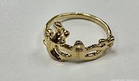 Front angle gold plated masquerade ring showing decorative ornate mask design