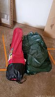Green inflatable Coleman air mattress partially unfolded on floor