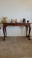 Full view of Broyhill wood grain side table with decorative items on top