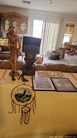 Image displaying tall sculpture, Egyptian-style bust, framed prints and dreamcatcher on a table in living room