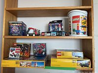Top shelf containing Funny Sphere box, grey plastic action truck, LEGO Technic 8714 box, white LEGO bucket