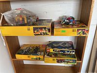 Four boxed Lego sets on shelf with a bag of Super Sonos parts
