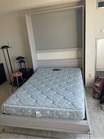 Full view of murphy bed in open position showing mattress and frame against wall