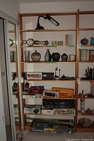 View of the shelving unit filled with various decorative items and boxes, showing the structure and number of shelves.