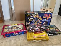 Photo showing a group of boxed construction and educational toy sets including KNex Big Ball Factory, Meccano, Zaks vehicle, and Sagesse kit.
