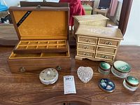 Lot of jewellery and trinket boxes with small assorted containers displayed on wooden table.
