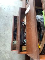 Wooden box half open showing some tools and other pieces inside.