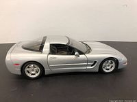Side view of silver diecast Chevrolet Corvette C5 model with doors and hood closed