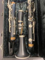 Disassembled clarinet parts inside the case lined with black soft material