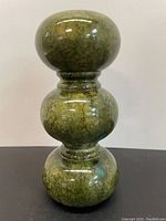 Front view of the green hand-carved alabaster vase showing the bulbous segmented design and polished surface.