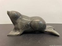 Front angled view of the carved stone animal sculpture, showing general shape, size and polished surface with natural veins.
