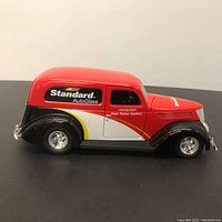 Side profile of the 1937 Ford diecast car model showing red and black paint with Standard AutoGlass branding