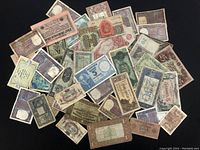 Assorted vintage paper banknotes in various conditions and designs, laid out on a flat surface.