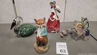 Photo showing entire lot with Royal Doulton figurine, Mr. Sly Fox figurine, blown glass swan, and two blown glass flowers