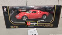 Photo of the Bburago boxed 1:18 scale Ferrari 250 LeMans 1965 model car from front view showcasing the packaging and model.
