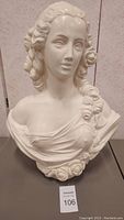 Front view of chalkware bust showing face, chest, and floral details.