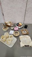 Full lot overview showing various marble collectible pieces including ashtrays, decorative bowls, and candle holders.
